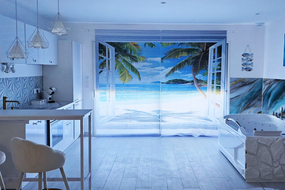 Modern white kitchen with a beach scene mural on the glass doors opening to a tropical beach run by palm trees and ocean beyond the doorways.